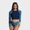 A woman modeling a two-piece swimsuit with a dark navy blue crewneck crop top and matching high-waisted bottoms, featuring a blue and teal mermaid scale pattern on the sleeves and bottom.