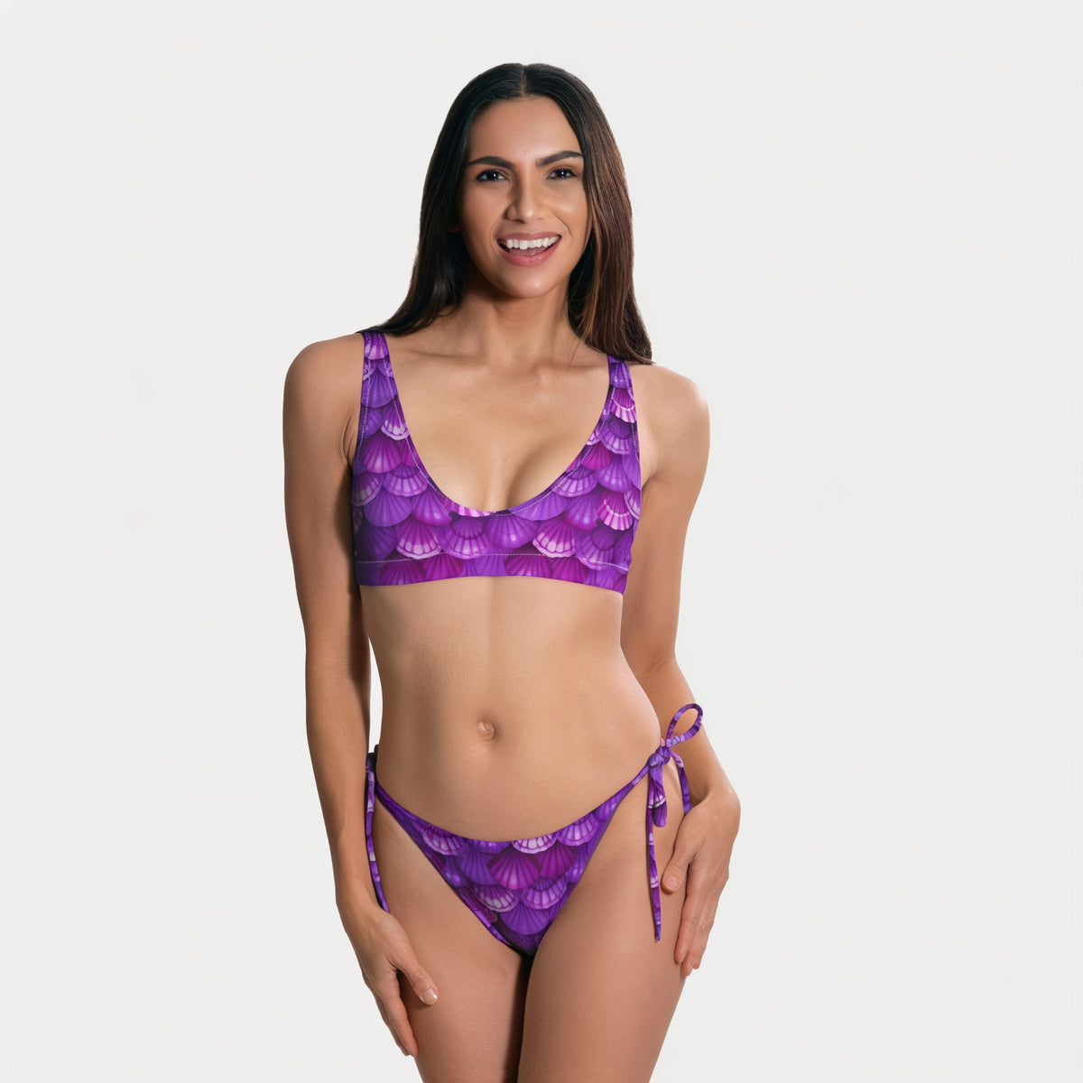 Woman wearing a purple bikini with fish-scale pattern on a white background